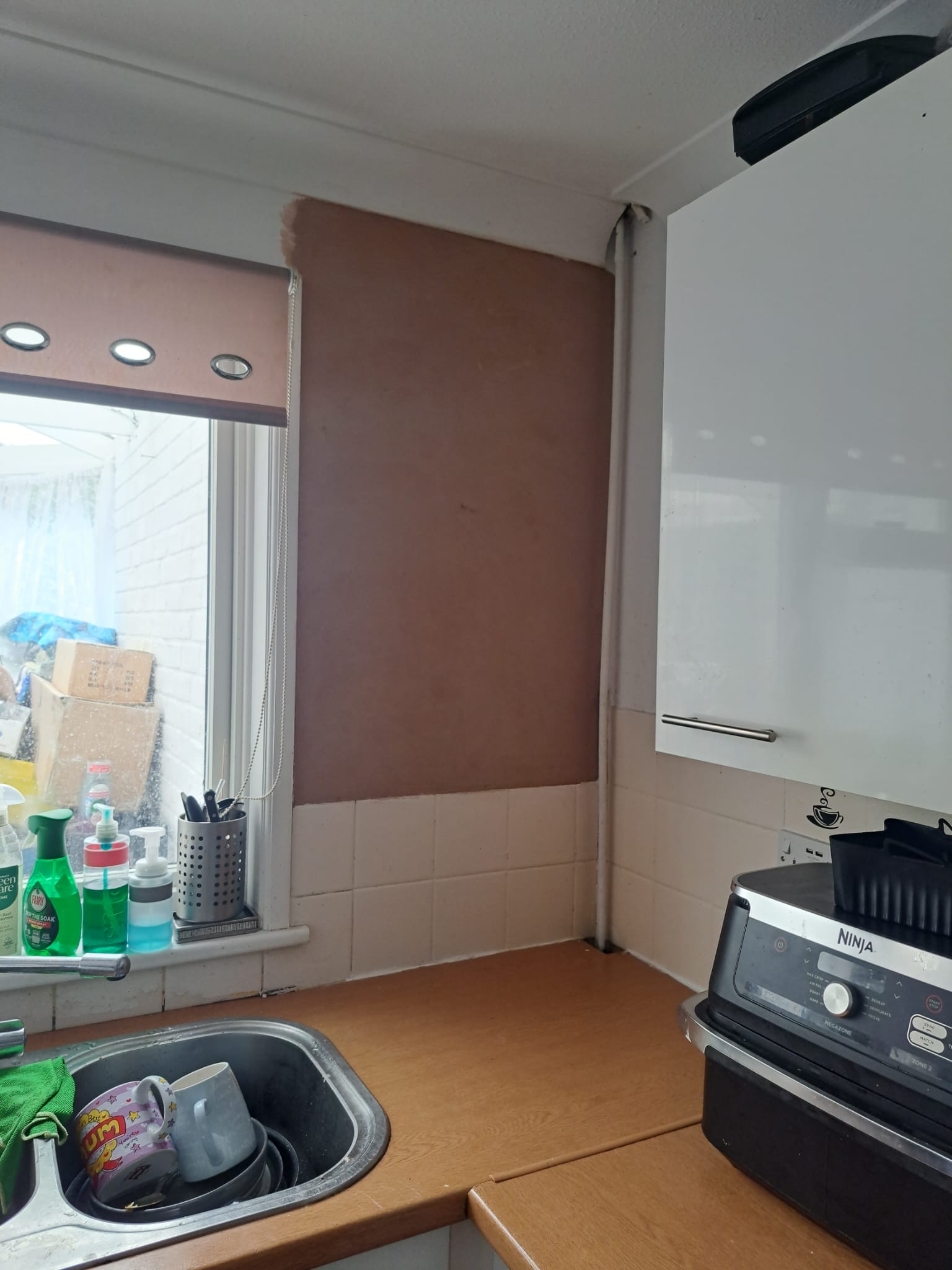 Kitchen wall with a section of new plaster applied above the splashback